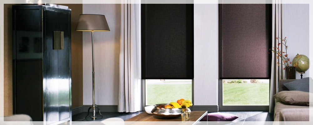 Dwie rolety wewnętrzne w odcieniach brązu w eleganckim wnętrzu we Wrocławiu, z widokiem na zieleń za oknem, na pierwszym planie stolik z owocami i dekoracyjny globus.