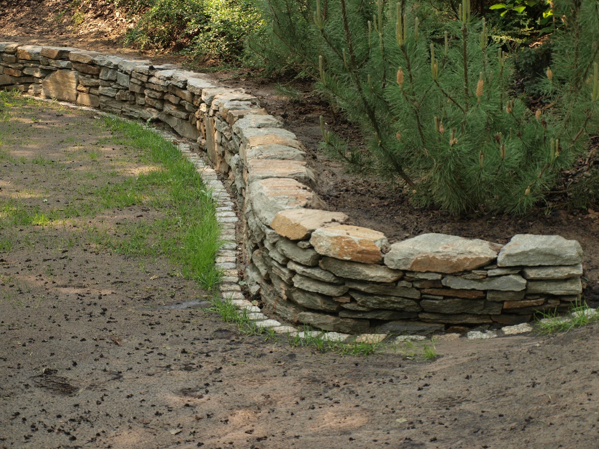 Mur oporowy z kamienia naturalnego , kostka granitowa oddzielająca trawnik ' na kółko kosiarki'