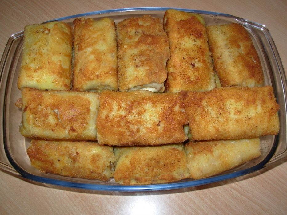 Krokiety z farszem ułożone w szklanym naczyniu żaroodpornym, widoczne złociste, chrupiące panierki.