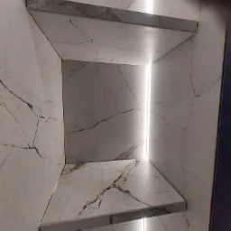 Półki z płytek imitujących marmur z podświetleniem LED wnęki, widok z dołu.