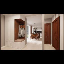 Tilmon Damian Piaseczny - Wnętrze domu z zabudowaną szafą wnękową z siedziskiem i wieszakami na ubrania, widok na jadalnię i kuchnię, brązowe drzwi z dekoracyjnym okręgiem w tle.