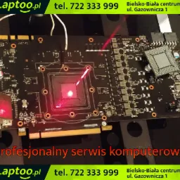 Płyta główna komputera poddawana diagnostyce laserowej w serwisie w Bielsku-Białej, widoczny układ scalony i komponenty elektroniczne podświetlone czerwoną wiązką lasera.