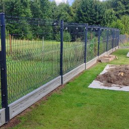 METALSTYL Mateusz Borek - Nowoczesne ogrodzenie panelowe z podmurówką betonową na zielonej działce, w tle altana ogrodowa. Widok na zainstalowane ogrodzenie w słoneczny dzień.