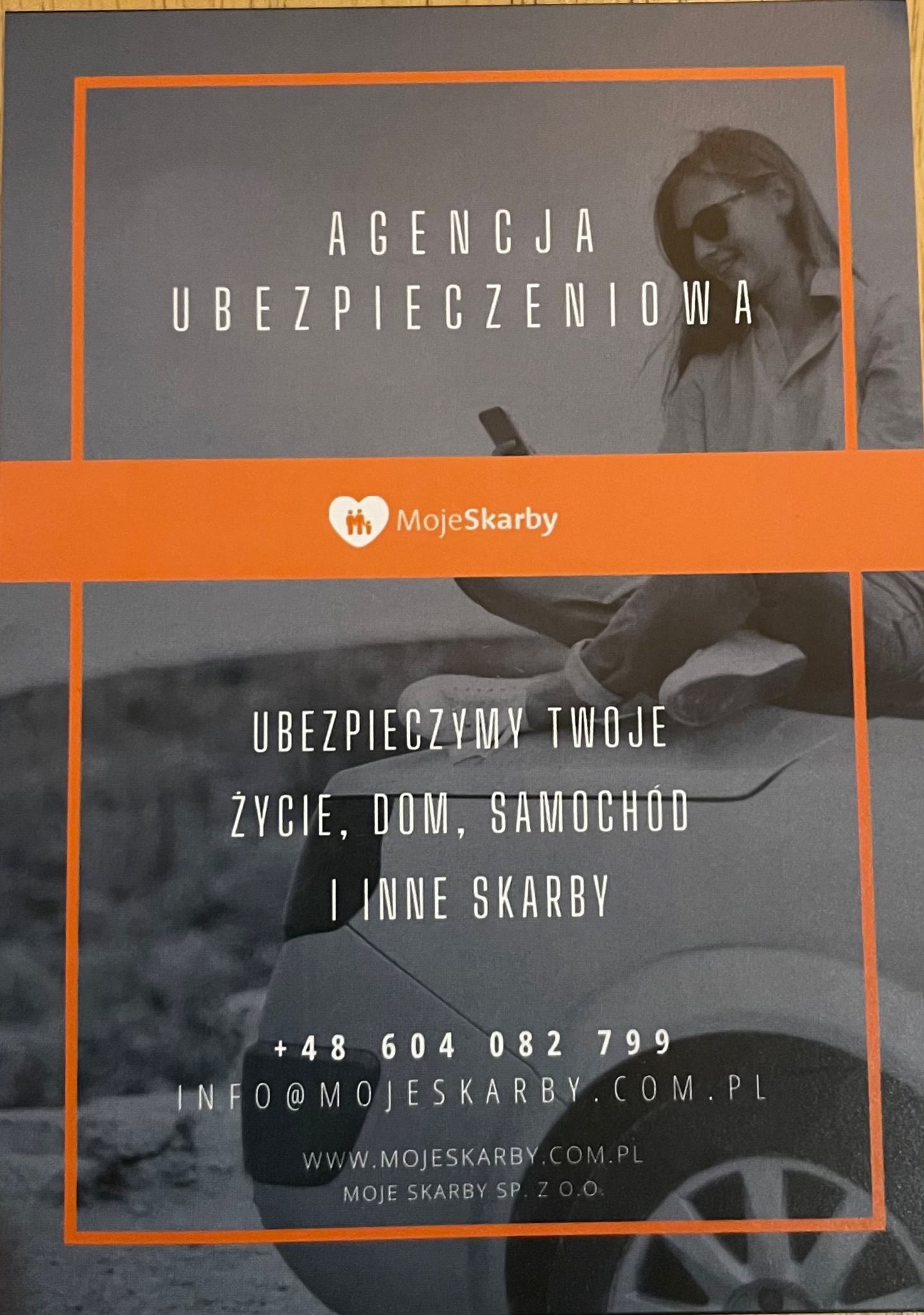 Ulotka reklamowa agencji ubezpieczeniowej 'MojeSkarby' z hasłem 'Ubezpieczymy Twoje Życie, Dom, Samochód i Inne Skarby', prezentująca kobietę korzystającą z telefonu i fragment samochodu.