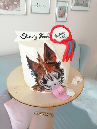 Tort urodzinowy z ręcznie malowanym wizerunkiem lisa, dekorowany napisem 'Stary Koń' i liczbą 40 w czerwonej ramce, umieszczony na drewnianej tacy z kostkami cukru.