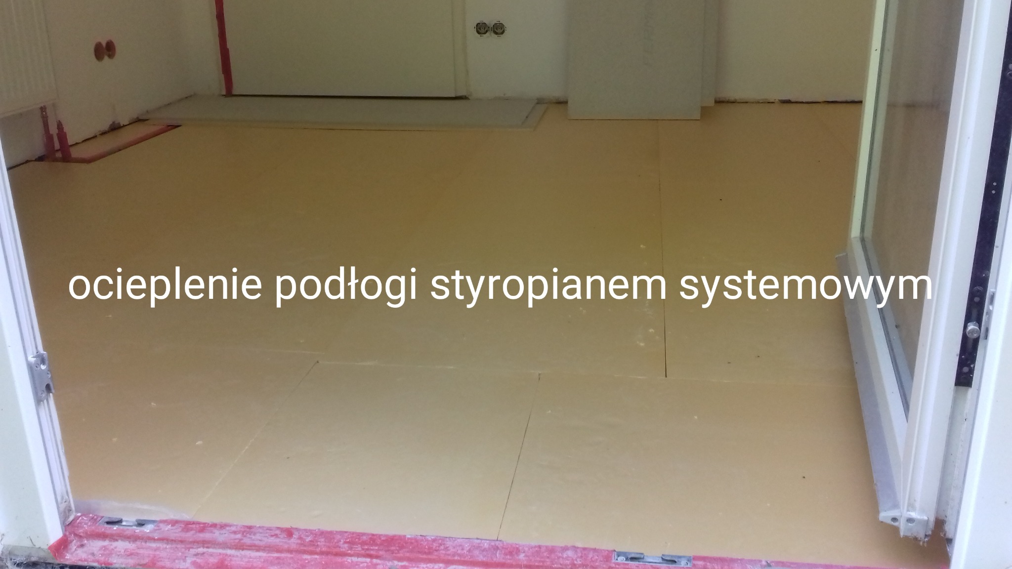 Przygotowanie podłoża pod panele: rozłożone płyty styropianowe na podłodze w pomieszczeniu przed układaniem paneli, widoczne fragmenty ściany i ramy drzwiowej.