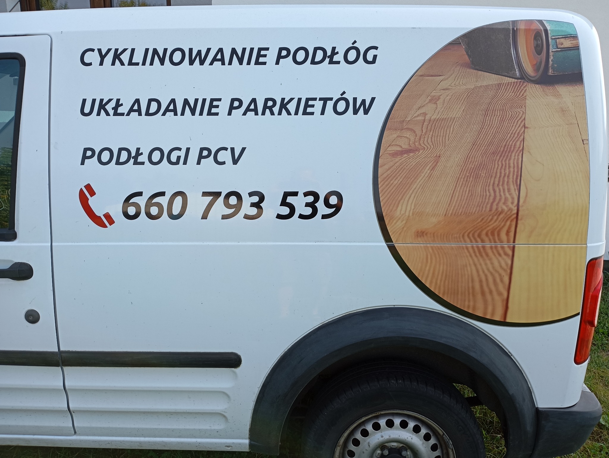 Biały samochód dostawczy z czarnymi napisami 'Cyklinowanie Podłóg', 'Układanie Parkietów', 'Podłogi PCV' i numerem telefonu, z grafiką przedstawiającą podłogę po cyklinowaniu.