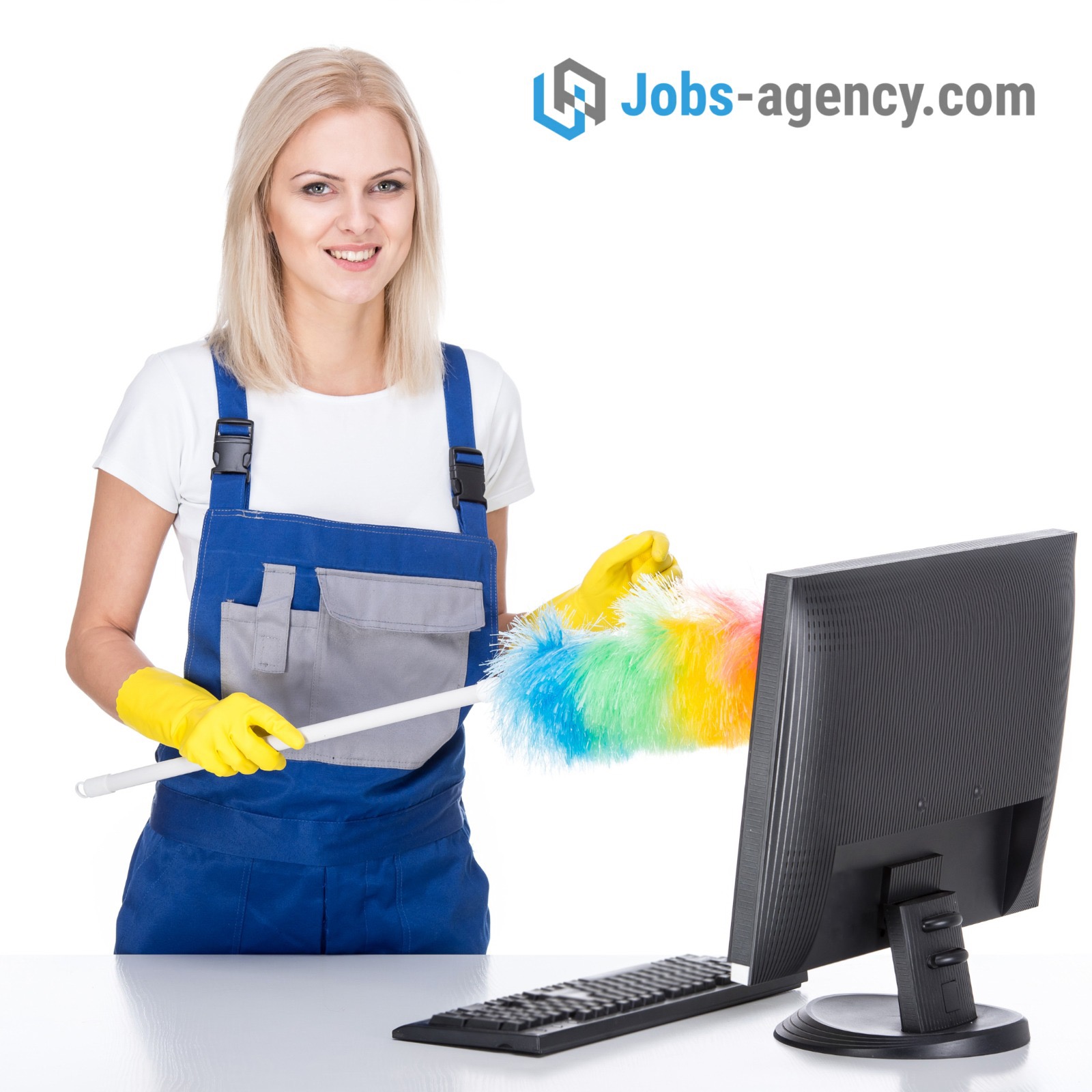 Kobieta w niebieskim kombinezonie i żółtych rękawicach czyści monitor komputera kolorową miotełką z piór, widoczne biurko i klawiatura, w tle logo firmy.