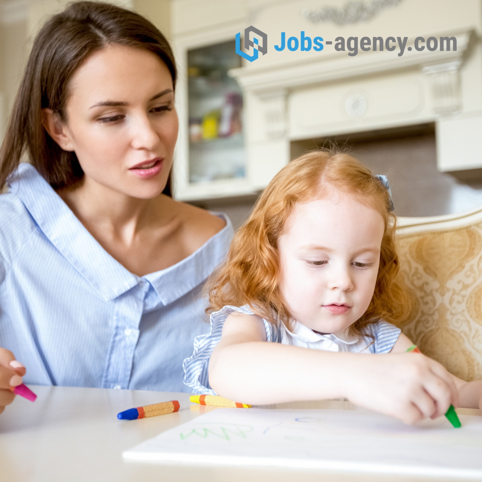 Kobieta w błękitnej koszuli nadzoruje, jak mała dziewczynka z rudymi włosami rysuje zieloną kredką na białej kartce, na stole leżą kolorowe kredki