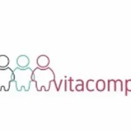 Logo Vitacomplex przedstawiające trzy uproszczone sylwetki ludzkie w kolorach czarnym, turkusowym i różowym, umieszczone obok nazwy firmy w kolorze różowym.