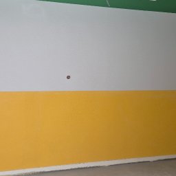 BC Bud - Ściana po malowaniu: góra biała, dół żółty, zielony sufit. Widoczny fragment podłogi i narożnik. Realizacja w pomieszczeniu oświetlonym naturalnym światłem.