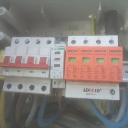 Rozdzielnica elektryczna z zabezpieczeniami przepięciowymi marki Adelid, widoczne przewody i elementy instalacji w Myszkowie.