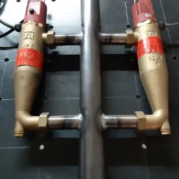 Zespawana stalowa konstrukcja rurowa z dwoma mosiężnymi zaworami termostatycznymi WP6 z czerwonymi etykietami, ustawiona na czarnej płycie montażowej z otworami.