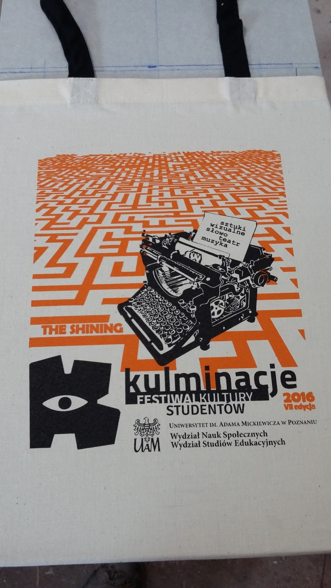 Torba bawełniana z nadrukiem grafiki nawiązującej do filmu 'The Shining', stylizowanej na labirynt, z czarną maszyną do pisania i napisem 'kulminacje festiwal kultury studentów'.