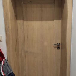 drzwi pokojowe z szeroką ościeżnicą, zostały wykonane z drewna dębowego lakierowanego, klamka producenta VDS model Roka, drzwi wykonane przez stolarza na zamówienie