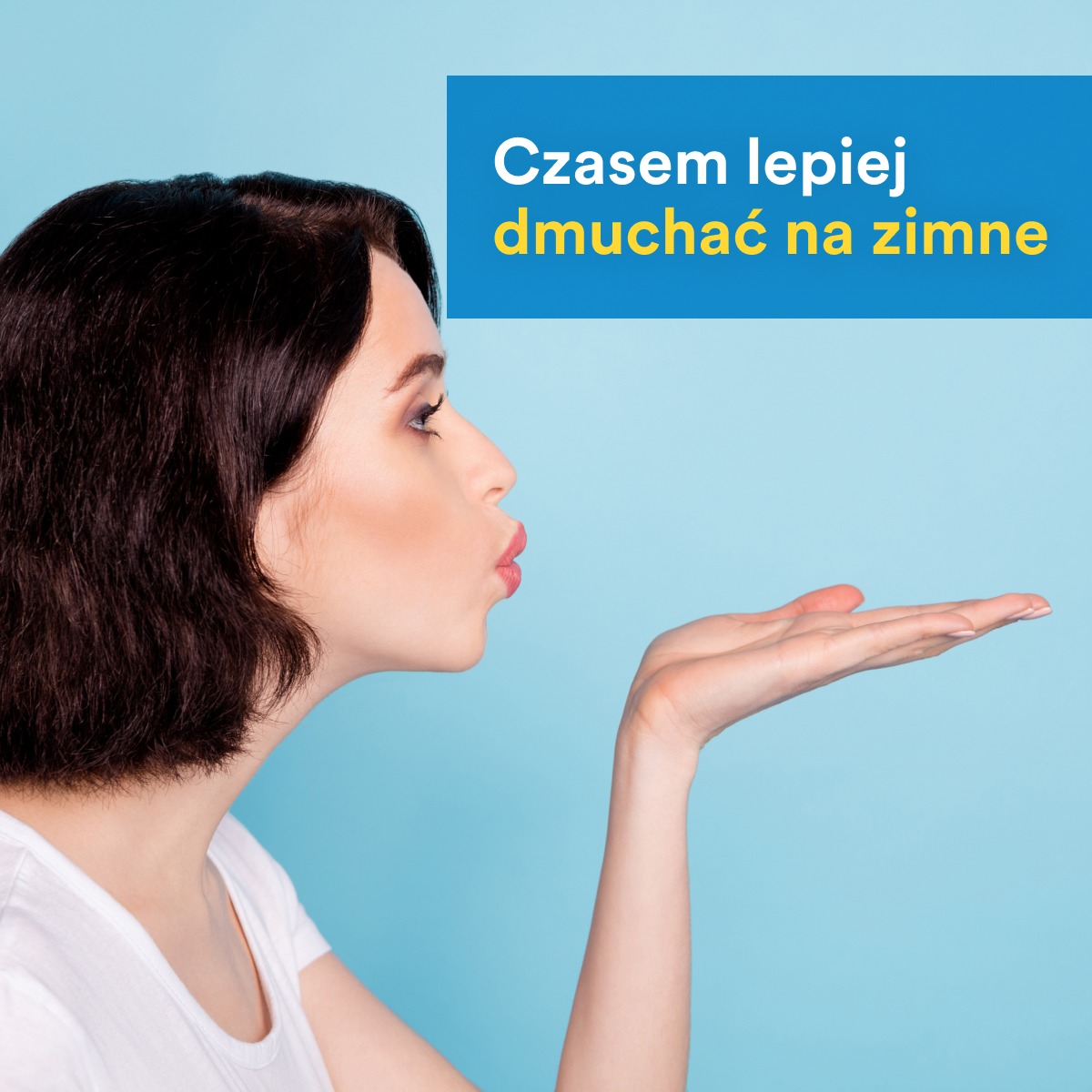 Kobieta z krótkimi, ciemnymi włosami dmucha w otwartą dłoń na tle błękitnego tła, z tekstem 'Czasem lepiej dmuchać na zimne' w górnym rogu.