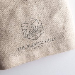 Dobrenczyk - Logo 'The Blessed Hills Olive Oil' na jutowym worku, wykonane przez firmę z Warszawy.