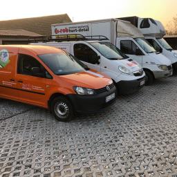 El-Rob Systemy Grzewcze - Flota samochodów dostawczych firmy z Jelcz-Laskowic specjalizującej się w systemach grzewczych, w tym pompy ciepła, fotowoltaika, kotły elektryczne i gazowe, zaparkowana na ażurowym parkingu.