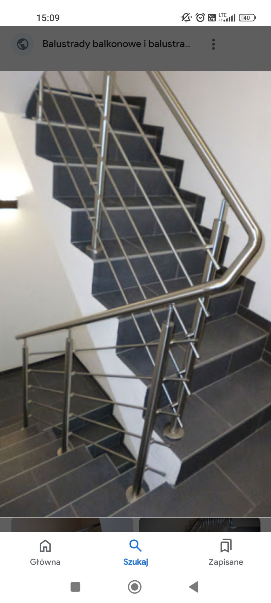 Wewnętrzne schody z ciemnymi płytkami i nowoczesną balustradą ze stali nierdzewnej, widok z góry, podkreślający minimalistyczny design i precyzję wykonania.