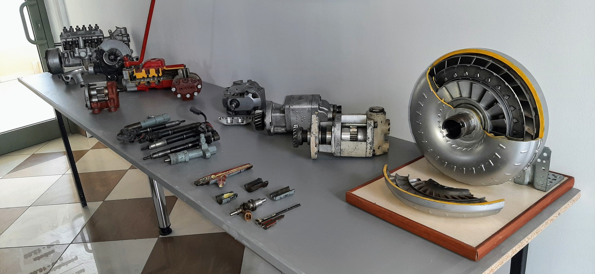 Przekroje silnika, pompy wtryskowej i turbiny na stole, prezentacja elementów składowych w celach edukacyjnych.