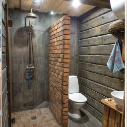 Regionalna grupa budowlana Mariusz pokutowski - Rustykalna łazienka z kabiną prysznicową oddzieloną ceglanym murkiem, drewnianymi ścianami i elementami retro armatury. Unikalny design z naturalnych materiałów.