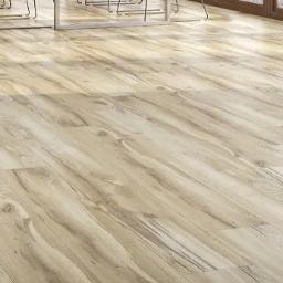 Krystian H - Jasne panele podłogowe z wyraźnym rysunkiem drewna, ułożone diagonalnie w przestronnym wnętrzu, z widocznymi nogami krzeseł i oknem w tle.