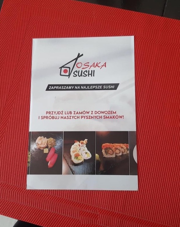 Ulotka reklamowa restauracji sushi Osaka Sushi z logo i hasłem 'Zapraszamy na najlepsze sushi' oraz zdjęciami przykładowych dań, leżąca na czerwonej podkładce.