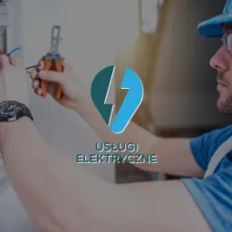 Instalator w niebieskim kasku i okularach ochronnych, obok rozdzielnicy z przewodami, używa szczypiec do zdejmowania izolacji, na pierwszym planie logo 'Usługi Elektryczne'.