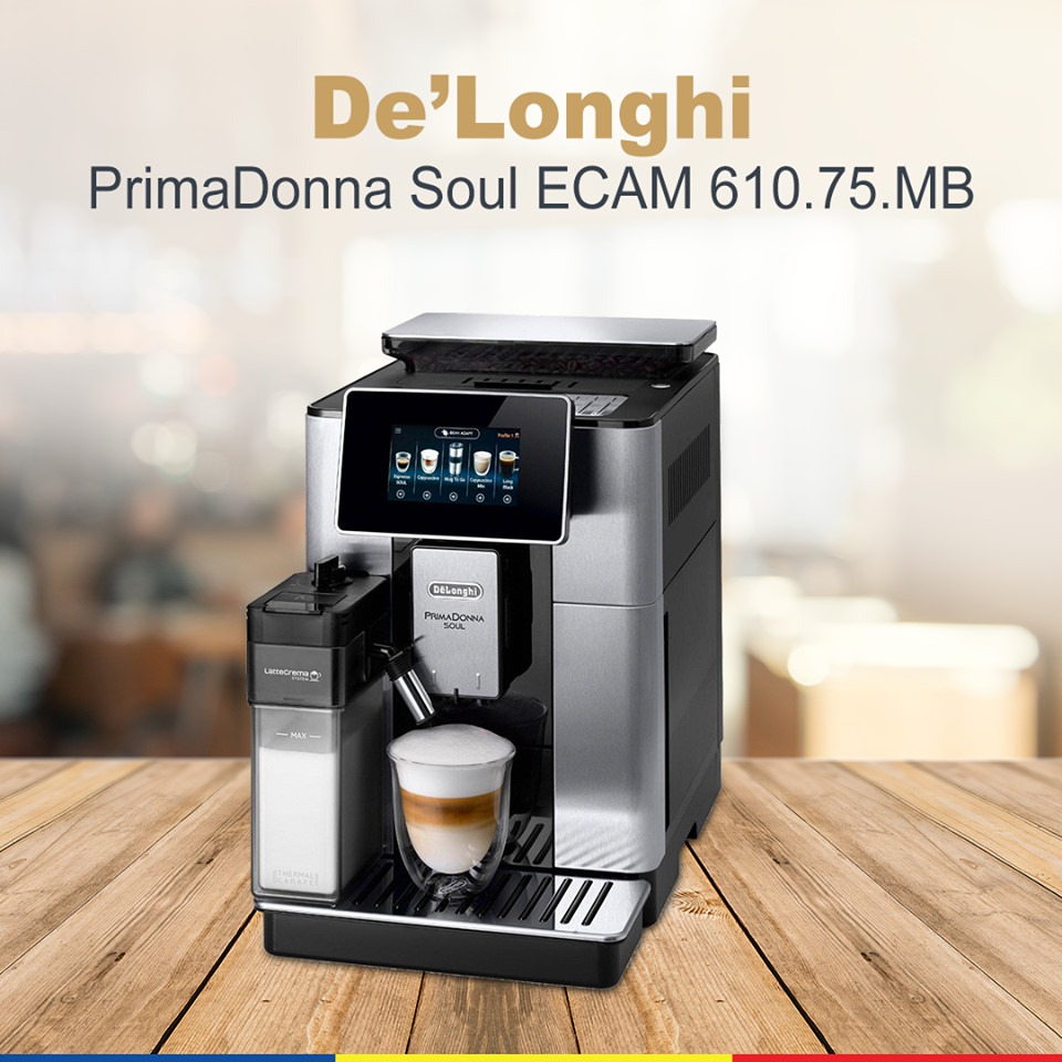 Automatyczny ekspres do kawy De'Longhi PrimaDonna Soul ECAM 610.75.MB z szklanką latte macchiato na drewnianym blacie.