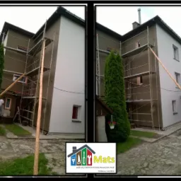 Dom dwukondygnacyjny w trakcie prac elewacyjnych, widoczne rusztowania, część ściany pomalowana na biało, druga część w kolorze brązowym. W tle zieleń i logo firmy w rogu.