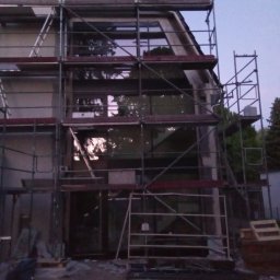 Kamil Ulikowski - Dom w trakcie montażu stolarki okiennej, widoczne rusztowania i przygotowane otwory okienne.