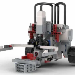 Model robota edukacyjnego z klocków, z chwytakiem i kołami, na białym tle.