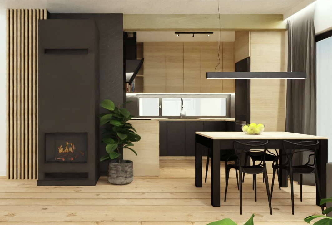 Wnętrze mieszkania z kominkiem, drewnianymi panelami ściennymi, czarną zabudową kuchenną i stołem z owocami w misce. Oświetlenie sufitowe w postaci długiej lampy LED.