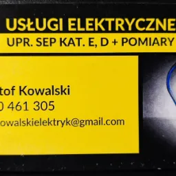 Wizytówka elektryka z żółtym tłem, danymi kontaktowymi i grafiką żarówki. Zawiera informację o uprawnieniach SEP kategorii E, D i pomiarach.