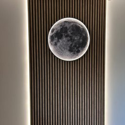 PerLOCK Patryk Sielawa - Okrągła lampa LED w kształcie księżyca zamontowana na drewnianej ściance z pionowych listew, oświetlona dodatkowo paskami LED po bokach, z widocznym fragmentem drabiny w dolnej części kadru.