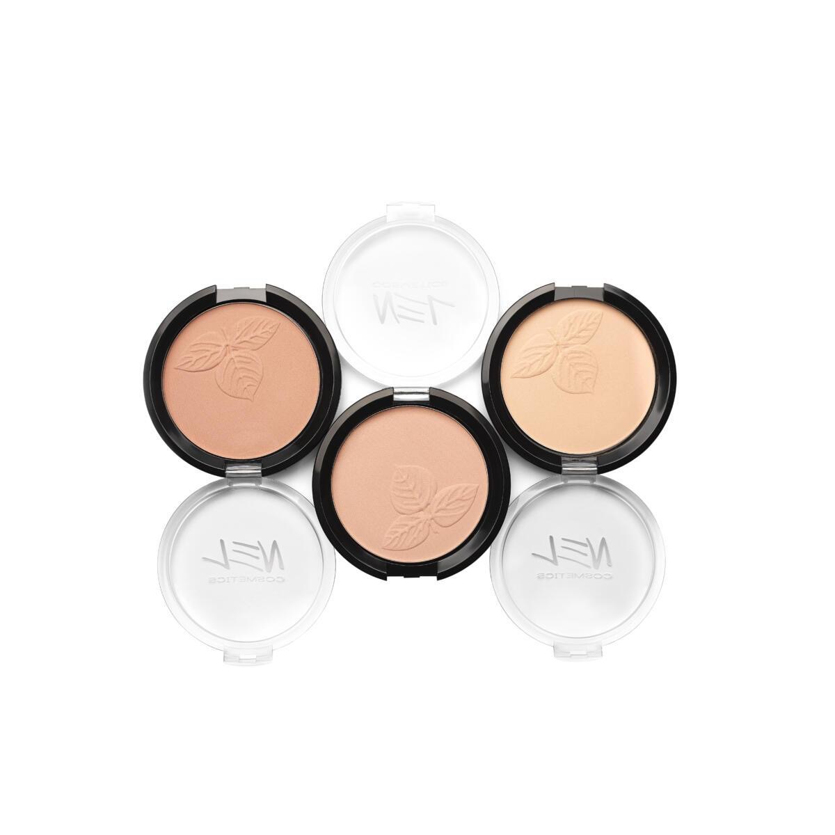 Pięć pudrów do twarzy w różnych odcieniach beżu, z wytłoczonym motywem liści, w czarnych i białych opakowaniach na białym tle.