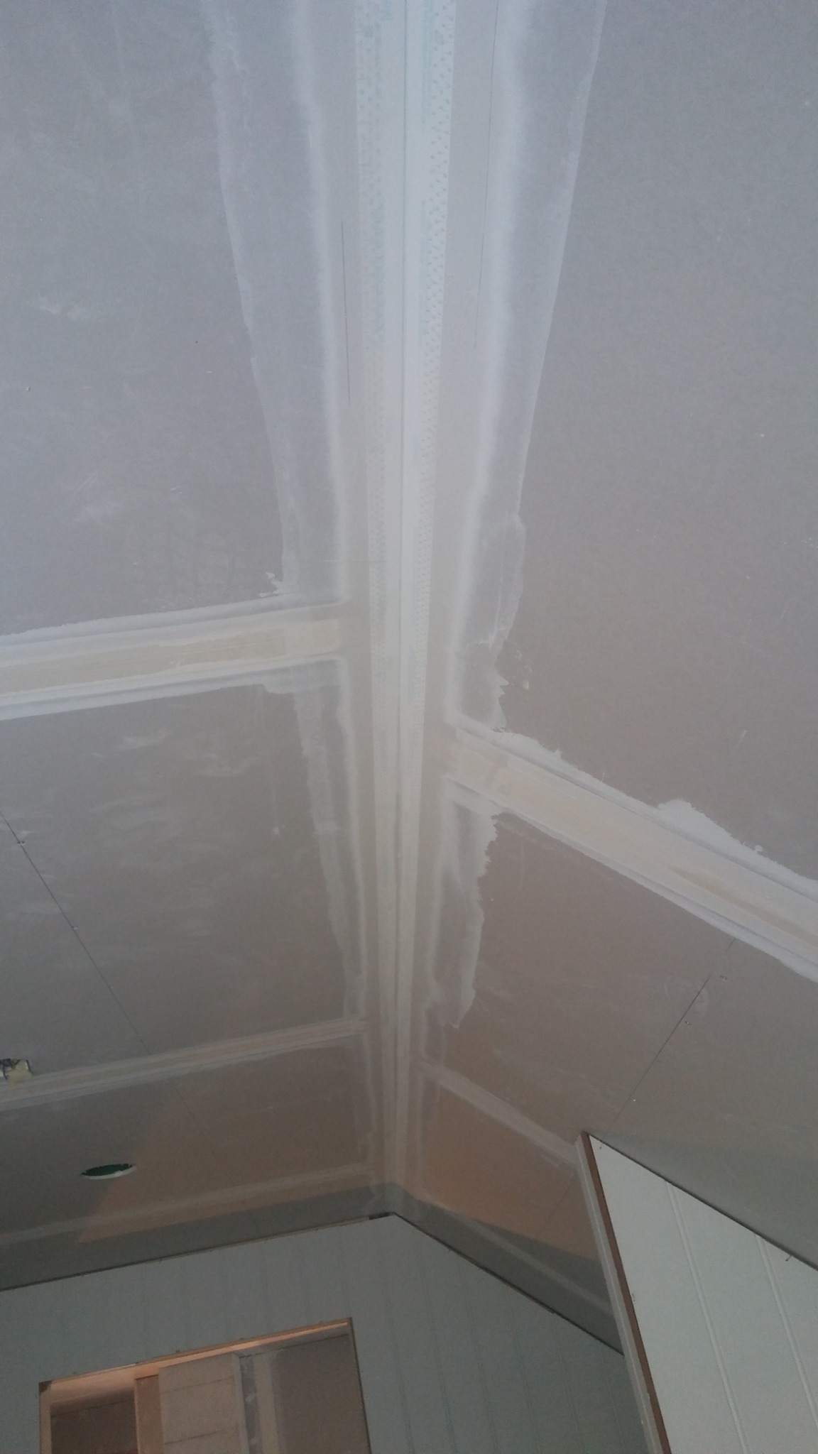 Sufit poddasza z płyt gipsowo-kartonowych, z widocznymi łączeniami wzmocnionymi taśmą i wstępnie wykończonymi masą szpachlową.