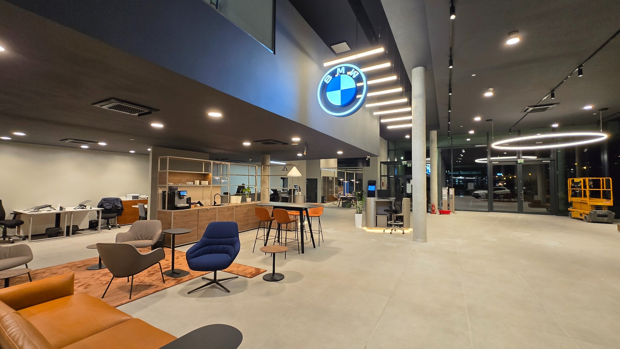 Wykończone wnętrze salonu samochodowego BMW w Barlinku. Widoczne meble, oświetlenie i logo marki. Nowoczesny design i przestronność.