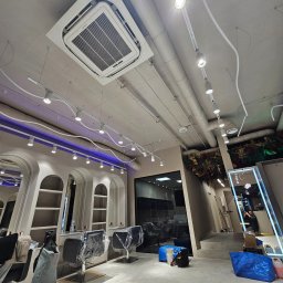 Grand Termo Norbert Moszczyński - Klimatyzacja kasetonowa zamontowana w salonie fryzjerskim w Warszawie, widoczne instalacje oświetleniowe i stanowiska pracy w trakcie przygotowywania.