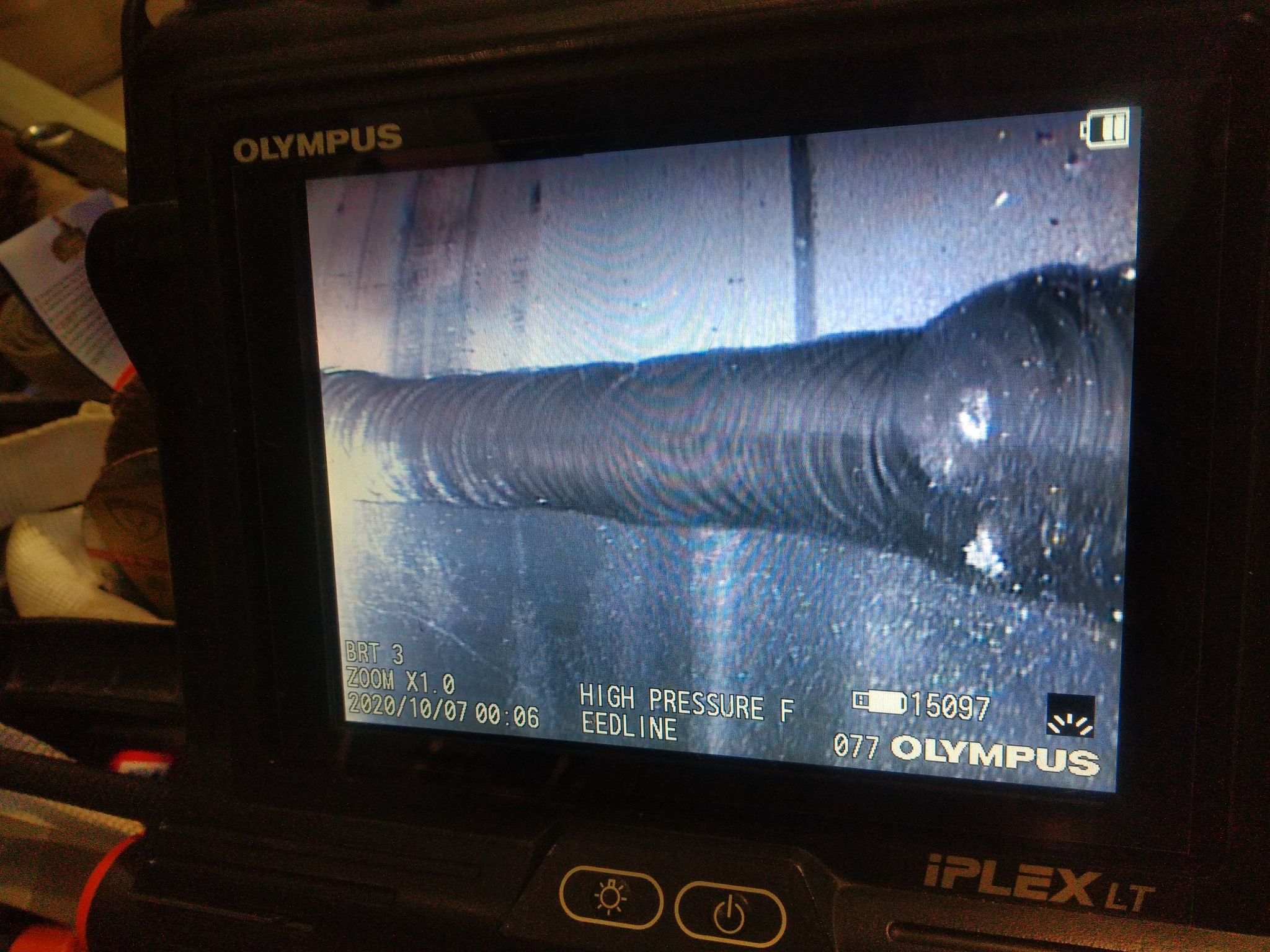 Ekran endoskopu przemysłowego marki Olympus, wyświetlający obraz spoiny z widocznymi śladami spawania, data i parametry ustawione na ekranie urządzenia.