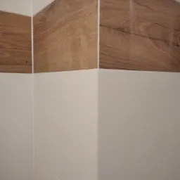 Połączenie białych i drewnopodobnych płytek w rogu pomieszczenia, widoczne fugi i dokładne wykończenie.