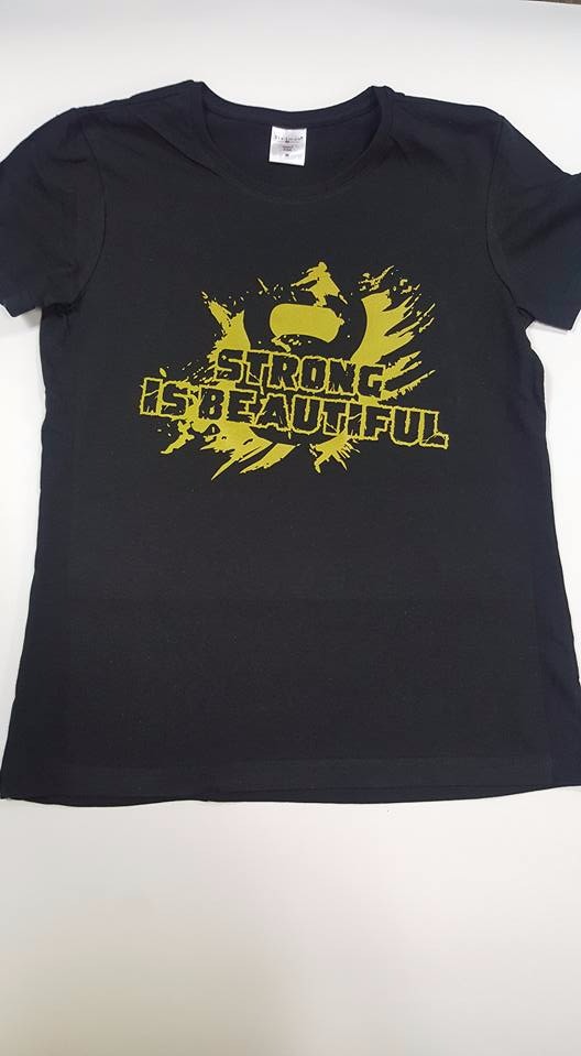 Czarna koszulka z żółtym nadrukiem 'STRONG IS BEAUTIFUL' i motywem graficznym sylwetki osoby ćwiczącej.