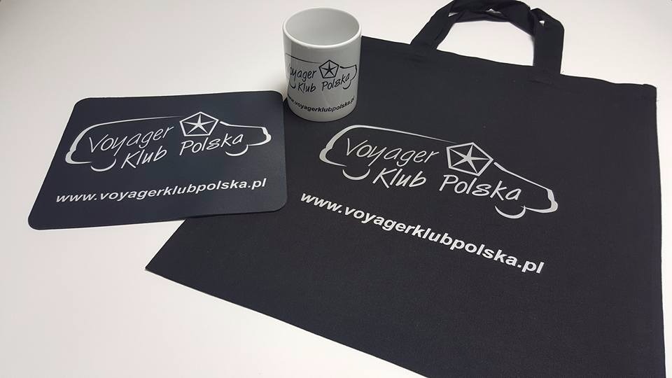 Czarna torba bawełniana, podkładka pod mysz i kubek z nadrukowanym logo 'Voyager Klub Polska' na białym tle.