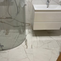 Wg home invest - Nowoczesna łazienka z kabiną prysznicową typu walk-in, białą szafką pod umywalką i płytkami imitującymi marmur z wyraźnym żyłowaniem.