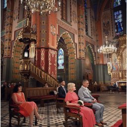 M.W.FotoPasja - Para młoda siedzi w kościele podczas ceremonii ślubnej, widoczny bogato zdobiony ołtarz i żyrandol