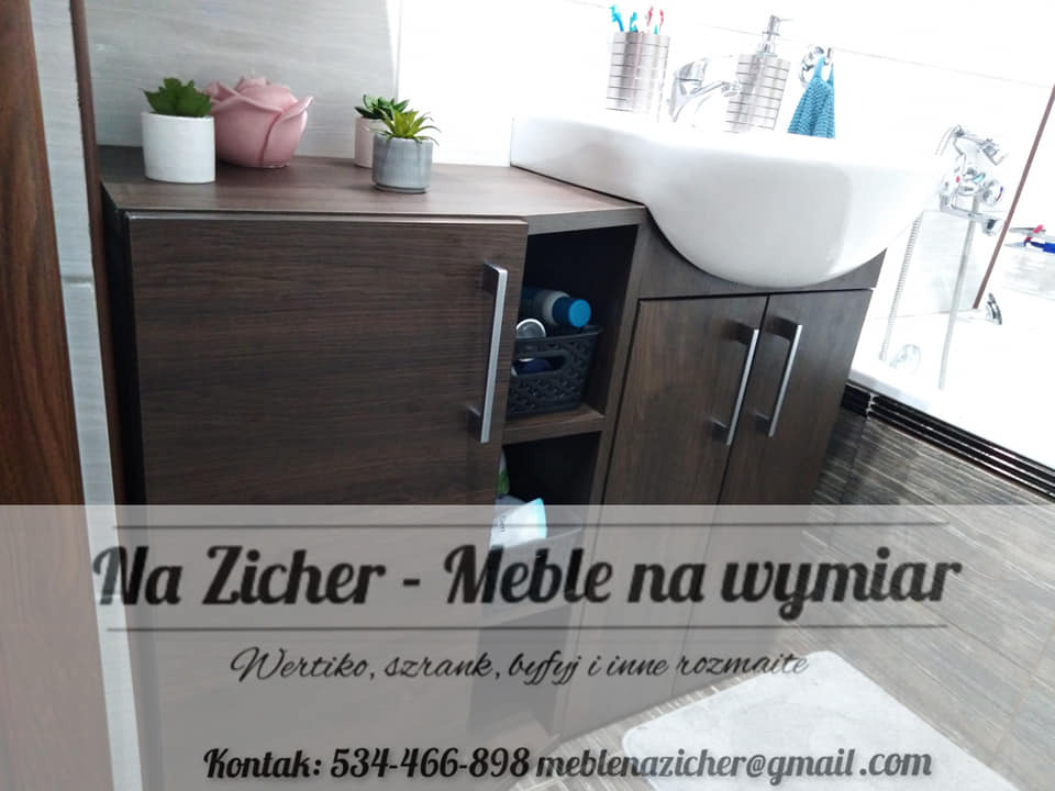 Szafka łazienkowa z ciemnego drewna pod umywalkę nablatową, z dekoracjami w postaci roślin w doniczkach i różowej figurki, widoczne akcesoria łazienkowe i ręcznik.