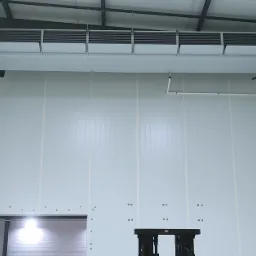 Wnętrze chłodni z zamontowanym stropowym agregatem chłodniczym marki SABROE, widoczne panele izolacyjne ścian i sufitu, oraz konstrukcja stalowa dachu.