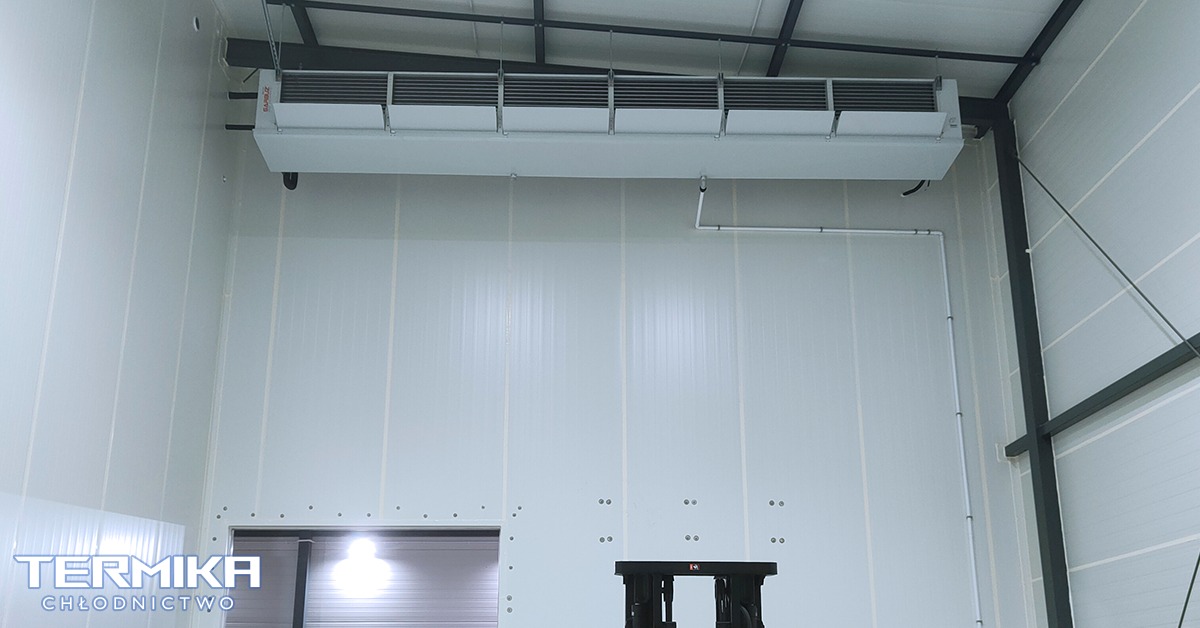 Wnętrze chłodni z zamontowanym stropowym agregatem chłodniczym marki SABROE, widoczne panele izolacyjne ścian i sufitu, oraz konstrukcja stalowa dachu.