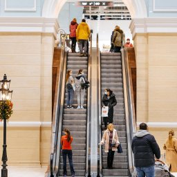 Izumrud Bud-Invest Sp. z o.o. - Wnętrze centrum handlowego Retroville w Kijowie z widokiem na ruchome schody, oświetlone dekoracyjną latarnią i udekorowane świątecznie.