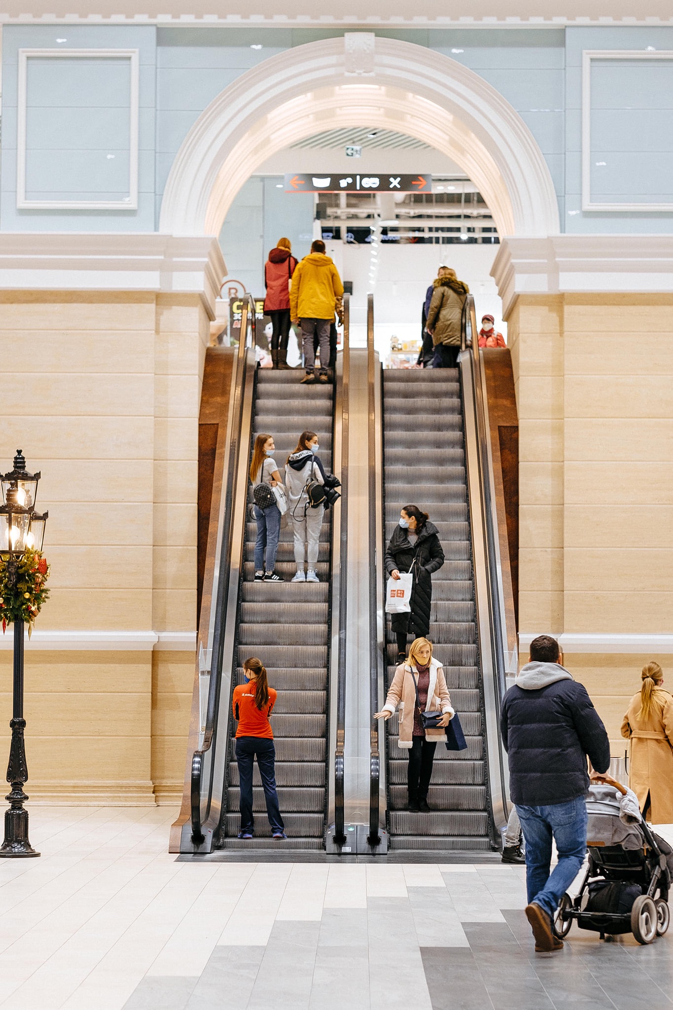 Wnętrze centrum handlowego Retroville w Kijowie z widokiem na ruchome schody, oświetlone dekoracyjną latarnią i udekorowane świątecznie.
